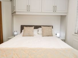 A bedroom with a bed and bedside tables at Easedale Lodge, Waterside Wood 2, White Cross Bay near Windermere