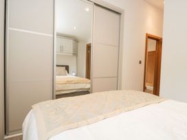 A bedroom with a bed and a wardrobe at Easedale Lodge, Waterside Wood 2, White Cross Bay near Windermere