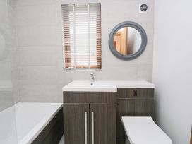 A bathroom with a bathtub, toilet, and vanity unit at Easedale Lodge, Waterside Wood 2, White Cross Bay near Windermere