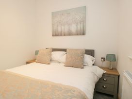 A bedroom with a bed and bedside table at Easedale Lodge, Waterside Wood 2, White Cross Bay near Windermere