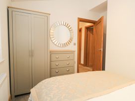 A bedroom with a wardrobe and a mirror at Easedale Lodge, Waterside Wood 2, White Cross Bay near Windermere