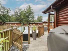 An outdoor area with a hot tub and wooden deck at Easedale Lodge, Waterside Wood 2, White Cross Bay near Windermere