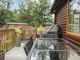 A table and chairs on a decking area at Easedale Lodge Waterside Wood 2 White Cross Bay near Windermere