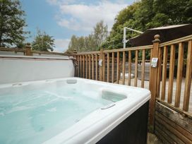A hot tub next to a wooden fence at Easedale Lodge, Waterside Wood 2, White Cross Bay near Windermere
