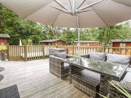 An outdoor seating area with a table and chairs at Easedale Lodge Waterside Wood 2 White Cross Bay near Windermere