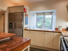 A kitchen with a refrigerator, sink, and countertop at The Old Manor House in Lifton