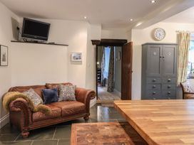 A living room with a sofa and television at The Old Manor House in Lifton