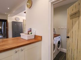 A laundry room with a washing machine and storage cabinet at The Old Manor House in Lifton