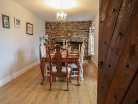 A dining room with a wooden table and chairs at The Old Manor House in Lifton