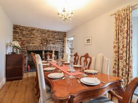A dining room with a wooden table and chairs at The Old Manor House in Lifton