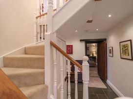 A hallway with staircase and paintings at The Old Manor House in Lifton