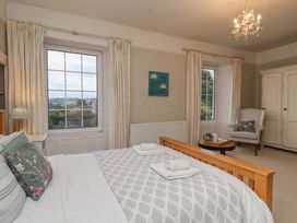 A bedroom with a bed and windows at The Old Manor House in Lifton