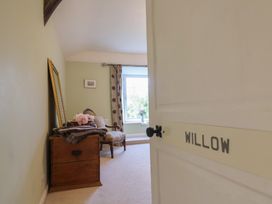 A bedroom with a mirror and a chair at The Old Manor House in Lifton