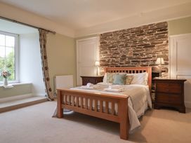 A bedroom with a bed and window at The Old Manor House in Lifton