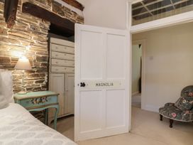 A bedroom with a stone wall and an open door at The Old Manor House in Lifton