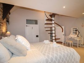 A bedroom with a bed and a spiral staircase at The Old Manor House in Lifton