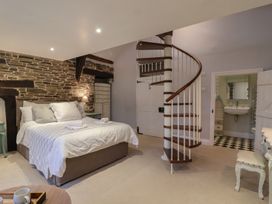 A bedroom with a bed and staircase at The Old Manor House in Lifton