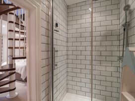 A shower with tiles and a spiral staircase at The Old Manor House in Lifton