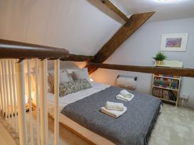 A bedroom with a bed and shelves of books at The Old Manor House in Lifton