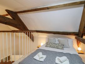 A bedroom with a bed and wooden beams at The Old Manor House in Lifton