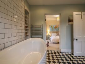 A bathroom with a bathtub and towel rail at The Old Manor House in Lifton
