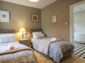 A bedroom with two beds and a nightstand at The Old Manor House in Lifton