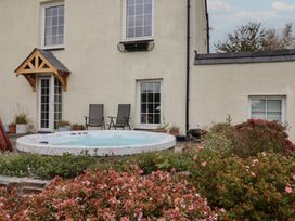 A garden with a hot tub and chairs at The Old Manor House in Lifton