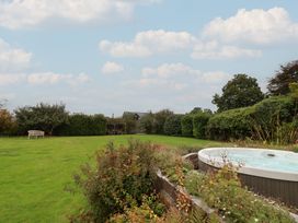 A garden with a hot tub and bench at The Old Manor House in Lifton