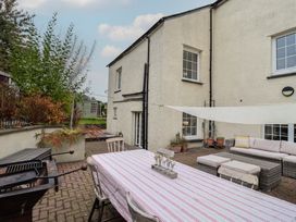An outdoor area with a table and seating at The Old Manor House in Lifton