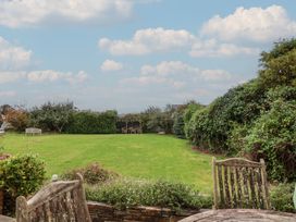 A garden with grass and seating areas at The Old Manor House in Lifton