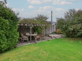 A garden with a table and chairs under a pergola at The Old Manor House in Lifton
