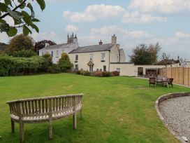 A garden with a bench and house in the background at The Old Manor House in Lifton