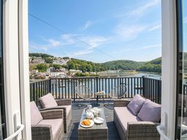 A balcony with chairs and a table overlooking water at Overdale