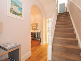 A hallway with a staircase and a console table at Overdale