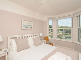 A bedroom with a bed and windows overlooking a view at Overdale in Looe
