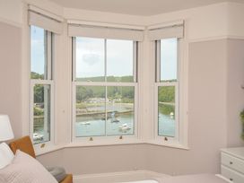 A bedroom with a view of boats on the water at Overdale in Looe