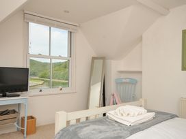 A bedroom with a television and a mirror at Overdale in Looe