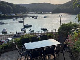A table and chairs overlooking water with boats at Overdale in Looe