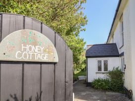 A gate and cottage with a sign at Honey Cottage in Ilfracombe