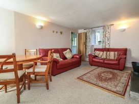 A living room with a dining table and chairs at Honey Cottage in Ilfracombe
