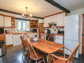 A kitchen with a wooden table and chairs at Honey Cottage Ilfracombe