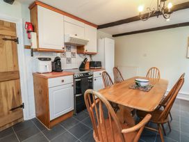 A kitchen with a table and chairs at Honey Cottage in Ilfracombe