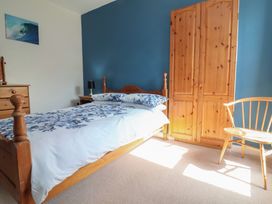 A bedroom with a bed and wardrobe at Honey Cottage in Ilfracombe