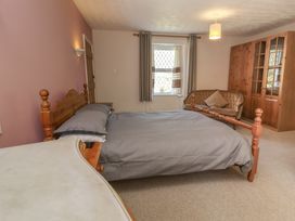 A bedroom with a bed and sofa at Honey Cottage Ilfracombe