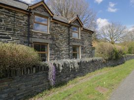 An outdoor view of a stone building with windows and a pathway at Ysgoldy in Dolwyddelan
