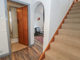 A hallway with a staircase and a shower door at Ysgoldy Dolwyddelan