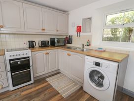 A kitchen with cabinets, oven, sink, and appliances at Ysgoldy in Dolwyddelan
