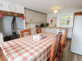 A kitchen with a dining table and appliances at Ysgoldy in Dolwyddelan