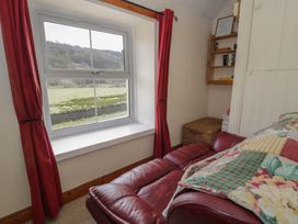 A bedroom with a window and sofa at Ysgoldy in Dolwyddelan