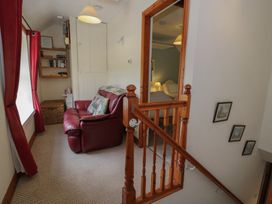A landing with a staircase and a chair at Ysgoldy in Dolwyddelan